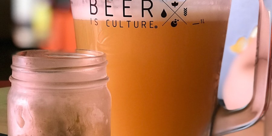 beverage filled pitcher beside empty jar