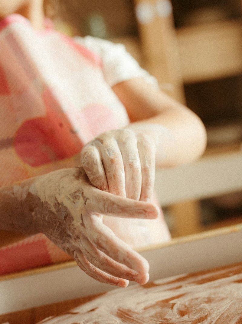 A child with flour on their hands and apron.